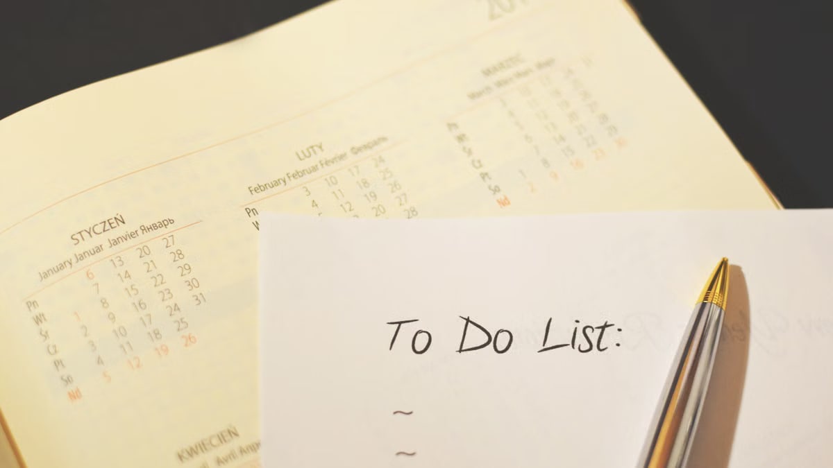 Close-up of a calendar and to-do list on a desk, emphasizing planning and organization.